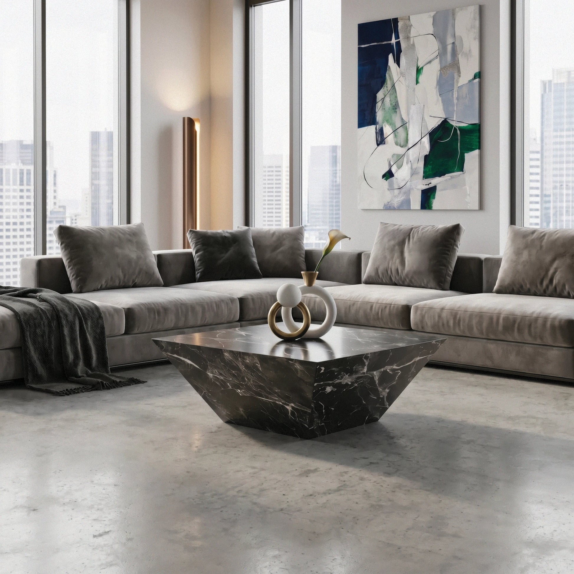 Modern living room with a gray sectional sofa, Alessandro marble coffee table from Marbeya Charm, and abstract art on the wall.