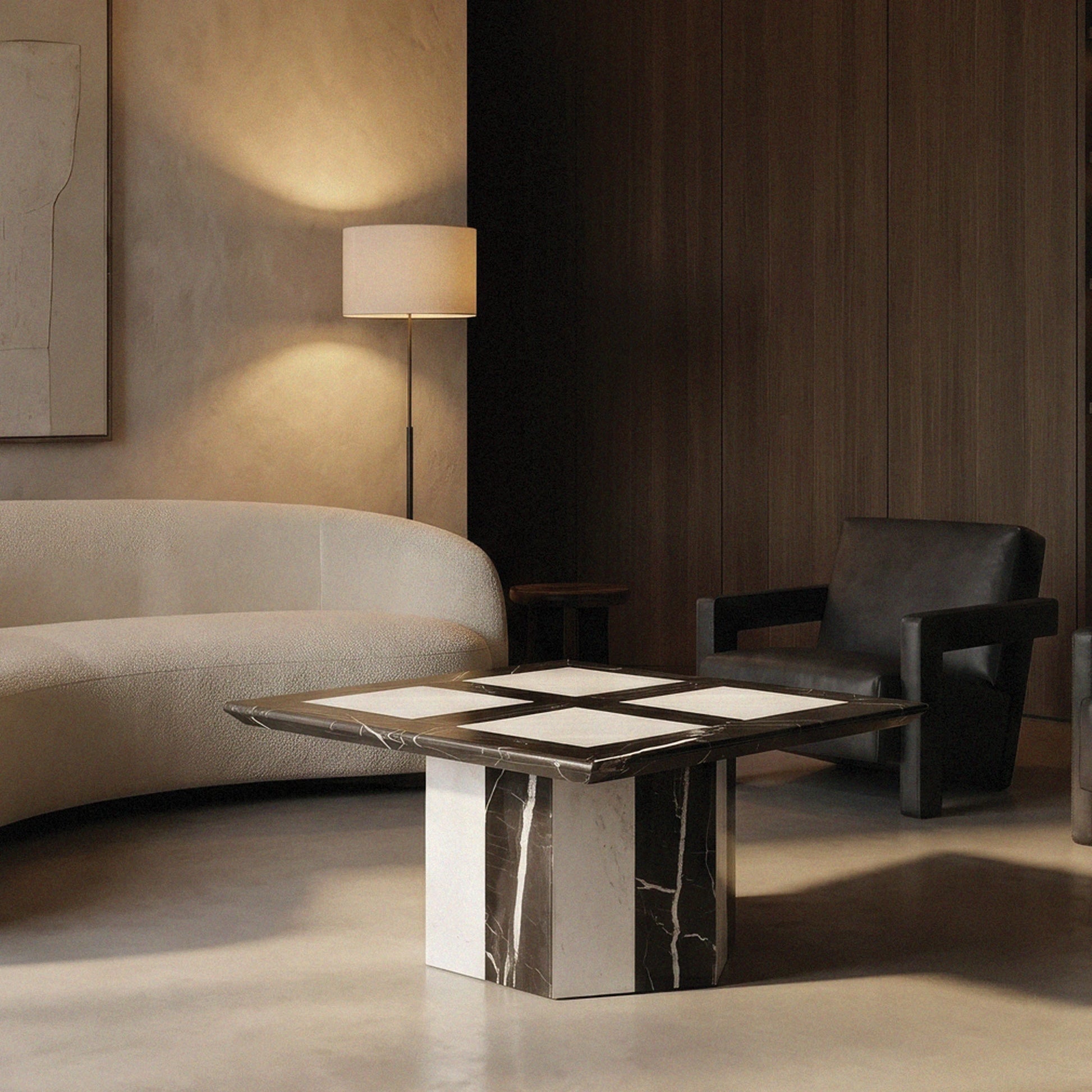 Modern living room with a Alina square marble coffee table from Marbeya Charm, gray sofa, and black armchair.