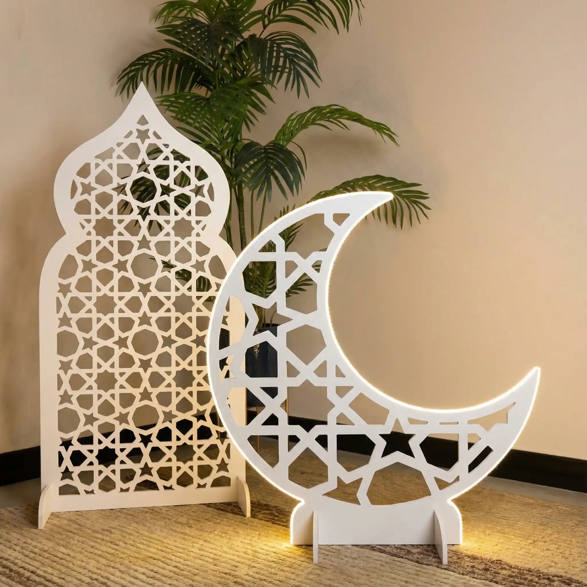 Decorative white Arabesque and crescent moon ornament against a beige wall with a plant.